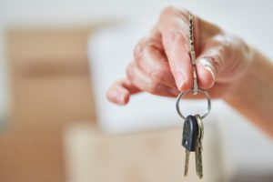 Hand holding key of property as a home buying concept