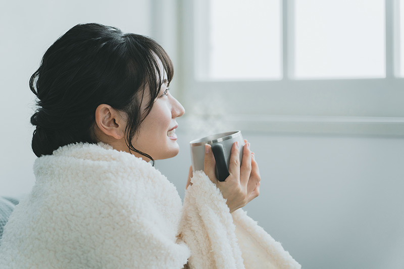 ホットドリンクを飲む女性